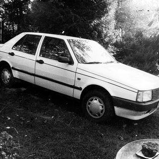 Vintage sedan parked on grassy yard.