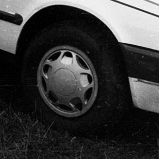 Vintage sedan parked on grassy yard.
