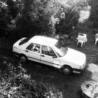 Aerial view of flooded driveway with submerged car.