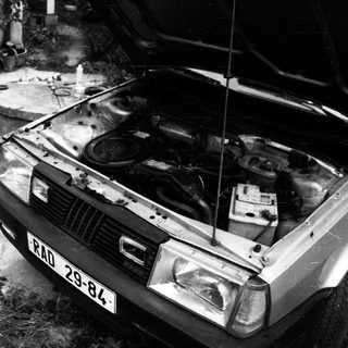 Old car with open hood in garage.