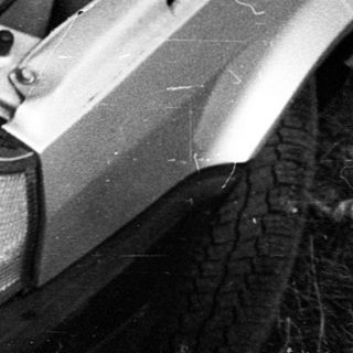Old car with open hood in garage.