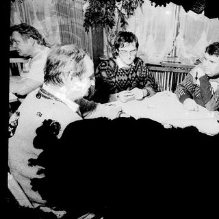 Group gathered around table playing board game indoors.