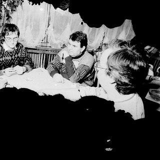 Group gathered around table playing board game indoors.