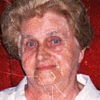 Elderly woman sitting in a wheelchair indoors.
