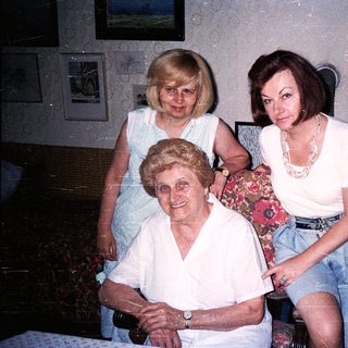 Three generations of women posing indoors together.