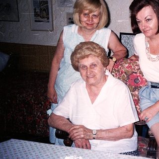Three generations of women posing indoors together.