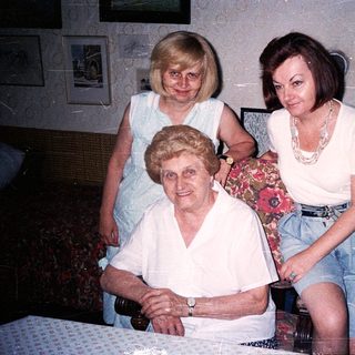 Three generations of women posing indoors together.