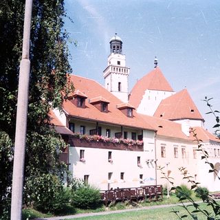 Historic castle with red-tiled roofs and tower.