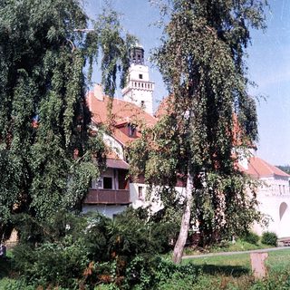 Historic building with red-tiled roof and tower.