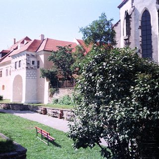 Historic European courtyard with castle ruins and church.