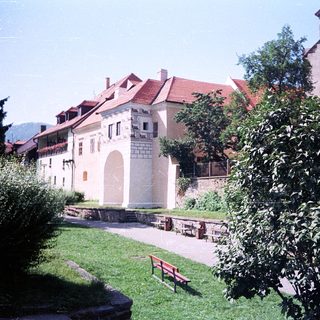 Historic European courtyard with castle ruins and church.