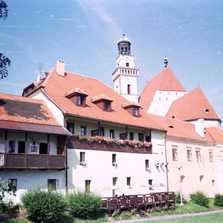 Historic castle with red-tiled roofs and towers.