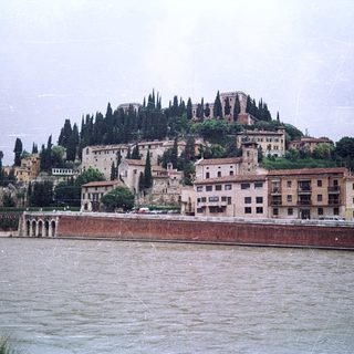 Medieval hilltop fortress by riverbank.