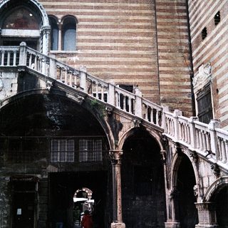 Historic Venetian arched courtyard with stone bridge.
