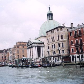 Venetian canal with historic church and gondolas.