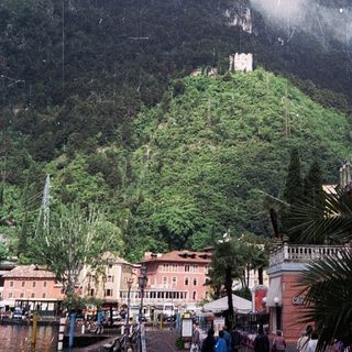 Majestic mountain fortress atop lush hillside village.