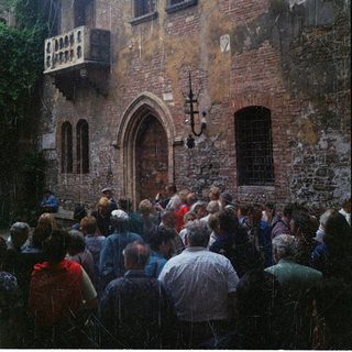 Crowd gathered outside historic stone building.