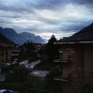 Mountain village with Villa Irma, cloudy sky.