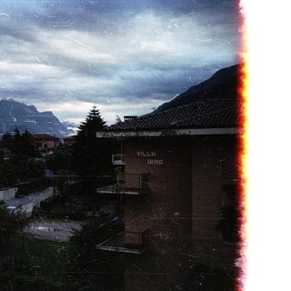 Mountain village with Villa Irma, cloudy sky.