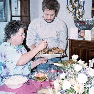 Family serving holiday meal together indoors.