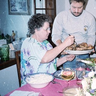 Family serving holiday meal together indoors.