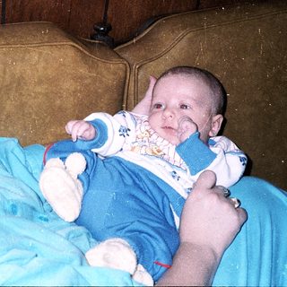 A woman holds a baby indoors.