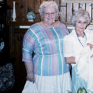 Family gathering holding newborn baby indoors.