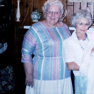 Four women posing with a baby indoors.