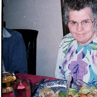 Woman posing with birthday cake and salad.