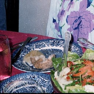 Woman posing with birthday cake and salad.