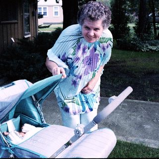Woman pushing stroller with baby inside.