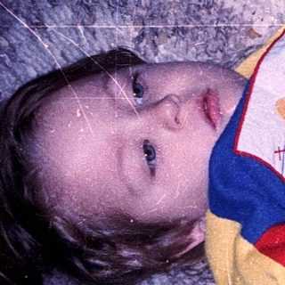 Child snuggled under winter blanket with stuffed toy.