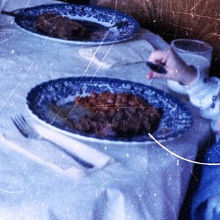 Two children eating cake at a table indoors.