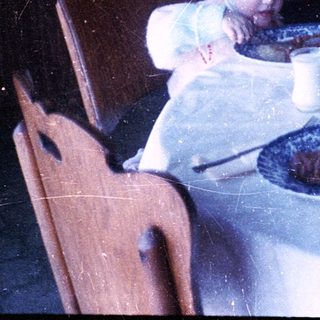 Two children eating cake at a table indoors.