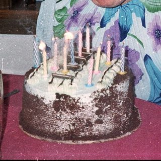 Woman blowing out birthday cake candles indoors.