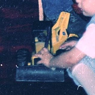 Man helping child play with toy car.