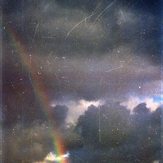 Rainbow in stormy night sky with meteors.