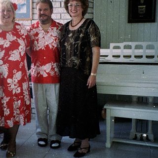 Four people posing indoors in casual summer attire.