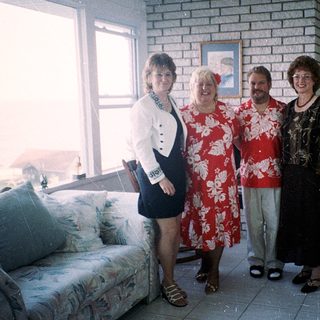 Four people posing indoors in casual summer attire.