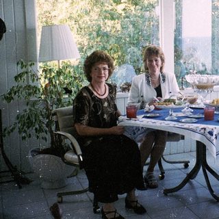 Family enjoying meal indoors near large windows.
