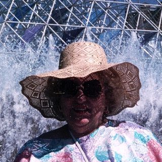 Woman enjoying water fountain show at amusement park.