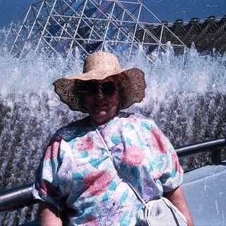 Woman enjoying water fountain show at amusement park.