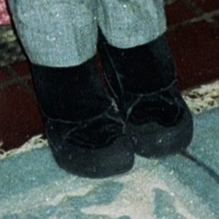 Two children posing indoors in 1980s-style clothing.