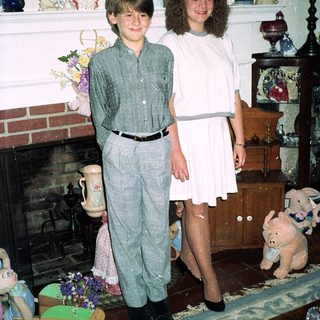 Two children posing indoors in 1980s-style clothing.