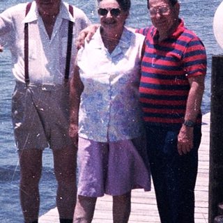 Three seniors posing by a waterfront dock.