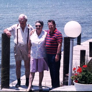 Three seniors posing by a waterfront dock.