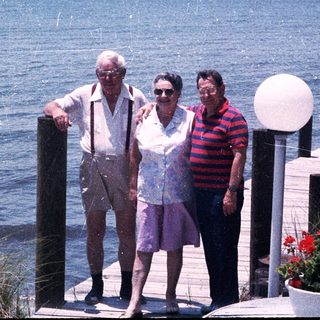Three seniors posing by a waterfront dock.
