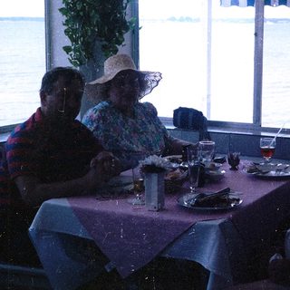 Group of four people dining together indoors near water.