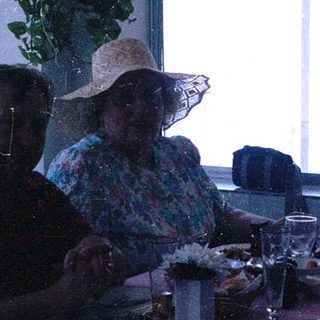 Group of four people dining together indoors near water.
