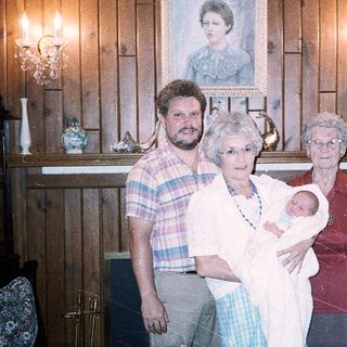 Family posing with newborn in vintage home setting.